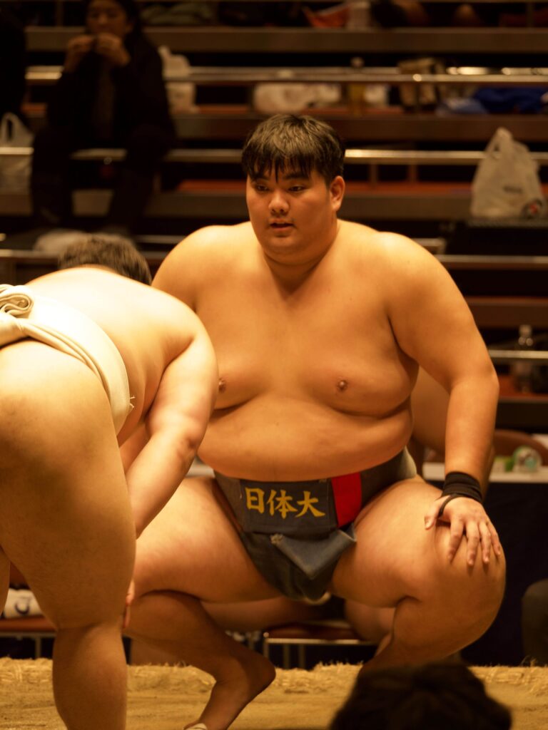 Deux lutteurs de sumo prêts à combattre sur le dohyō (ring traditionnel) lors d’un tournoi au Japon.