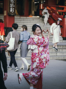 Jeune femme japonaise en kimono fleuri posant devant le temple Senso-ji à Tokyo